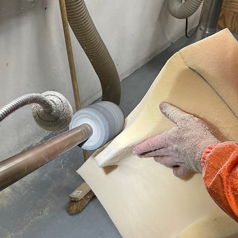 Der Schaumstoff für eine Sitzschale wird geschliffen.